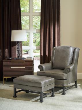 Room Scene: HC1756-53 Marlborough Lounge Chair and HC1756-89 Marlborough Ottoman shown in HC328 Leather with Kohl finish and HC765-70 Hamlin 2 Drawer Nightstand shown in Espresso finish with Antique Brass legs and Hardware.